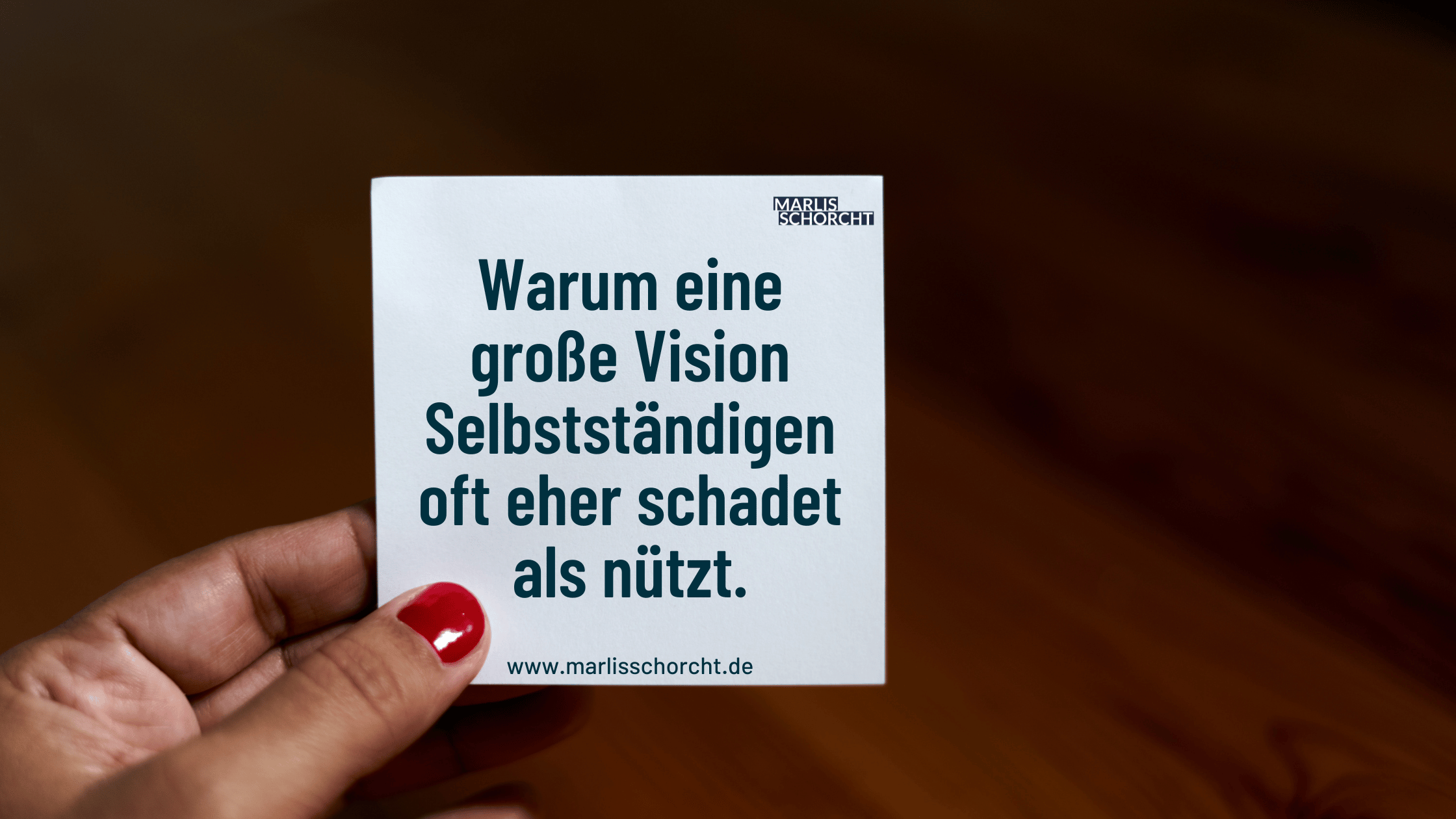 Eine Hand mit rotem Nagellack hält eine Karte mit der Aufschrift „Warum eine große Vision Selbstständigen oft eher schadet als nützt“. Das Bild greift einen ungewohnten Gedanken auf, der viele Selbstständige beschäftigt: Brauche ich wirklich eine große Vision – oder blockiert sie mich nur? Der Beitrag erklärt, warum zu viel Zukunftsdenken oft vom Handeln abhält und wie du stattdessen klar, bodenständig und wirksam bleibst.